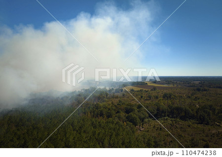 View from above of dense smoke from woodland and field on fire rising up polluting air. Concept of natural disaster View from above of dense smoke from woodland and field on fire rising up polluting air. Concept of natural disaster 110474238