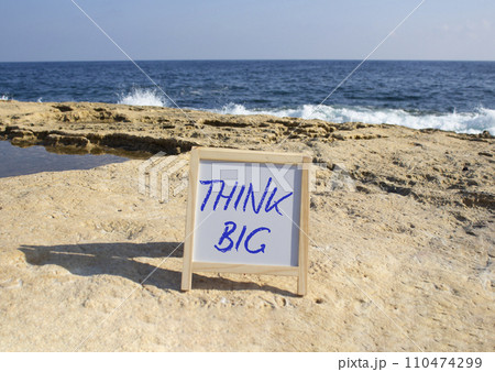 Think big symbol. Concept words Think Big on white chalk background. Beautiful sea background. Business and Think big concept. Copy space. Think big symbol. Concept words Think Big on white chalk background. Beautiful sea background. Business and Think big concept. Copy space. 110474299