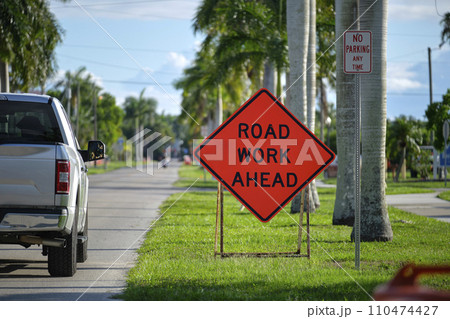 Road work ahead sign on street site as warning to cars about construction and utility works 110474427