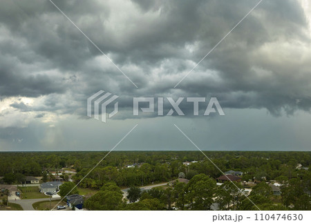 Landscape of dark ominous clouds forming on stormy sky before heavy thunderstorm over rural town area 110474630