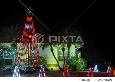 Front yard with brightly illuminated christmas decorations. Outside decor of florida family home for winter holidays 110474689