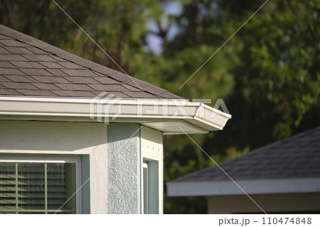 Closeup of house roof top covered with asphalt or bitumen shingles. Waterproofing of new building Closeup of house roof top covered with asphalt or bitumen shingles. Waterproofing of new building 110474848