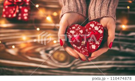 Hands cradling a heart shaped Valentine gift box 110474878