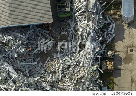 Beg pile of scrap aluminum metal siding from ruined houses after hurricane Ian swept through Florida. Recycle of broken parts of mobile homes Beg pile of scrap aluminum metal siding from ruined houses after hurricane Ian swept through Florida. Recycle of broken parts of mobile homes 110475008
