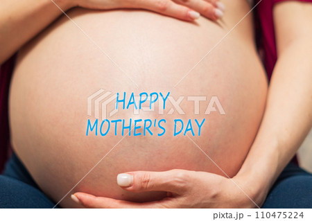 Essence of motherly love with a Happy Mothers Day message lovingly placed on an expectant mothers belly. Essence of motherly love with a Happy Mothers Day message lovingly placed on an expectant mothers belly. 110475224
