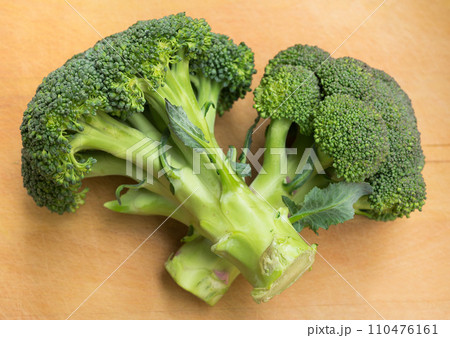 Healthy broccoli and florets on wooden board Healthy broccoli and florets on wooden board 110476161