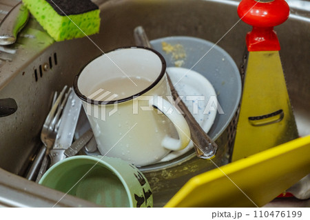 dirty dishes in sink 110476199