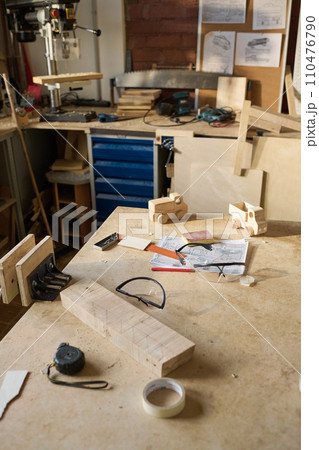 High angle view at workstation with tools in carpentry workshop lit by sunlight, copy space 110476790
