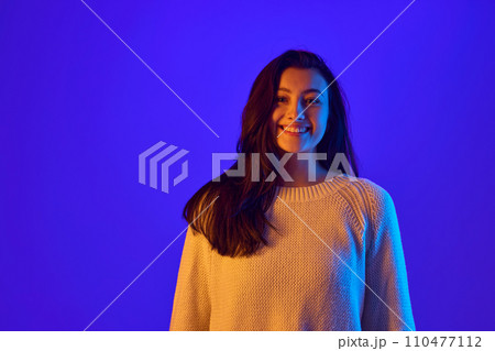 Eye Contact. Portrait of young girl looks directly at camera, establishing strong connection with viewer against gradient blue background. Eye Contact. Portrait of young girl looks directly at camera, establishing strong connection with viewer against gradient blue background. 110477112