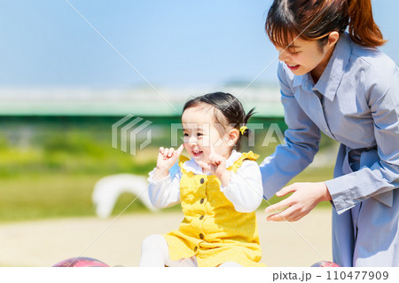 公園で仲良く遊ぶ親子 110477909