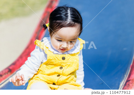 公園の滑り台で遊ぶ幼児 110477912