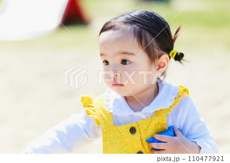 砂場で遊ぶかわいい女の子 砂場で遊ぶかわいい女の子 110477921