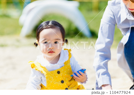 公園で砂遊びする親子 公園で砂遊びする親子 110477924