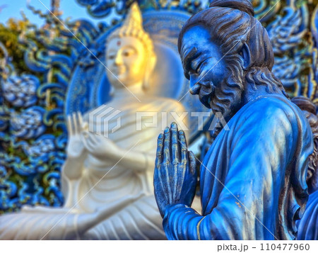 Praying monk statue at Wat Rong Suea Ten Blue temple, Chiang Rai, Thailand 110477960
