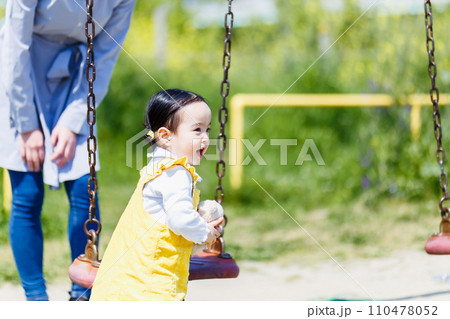 公園のブランコで遊ぶかわいい女の子とママ 公園のブランコで遊ぶかわいい女の子とママ 110478052
