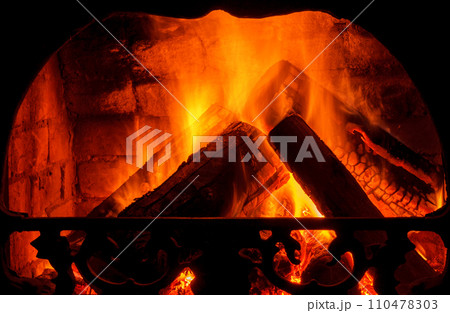 Wood burning in fireplace. Fire keep warm. Crest of flame on burning wood in fireplace Wood burning in fireplace. Fire keep warm. Crest of flame on burning wood in fireplace 110478303