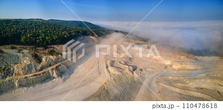 Aerial view of open pit mining of limestone materials for construction industry with excavators and dump trucks. 110478618