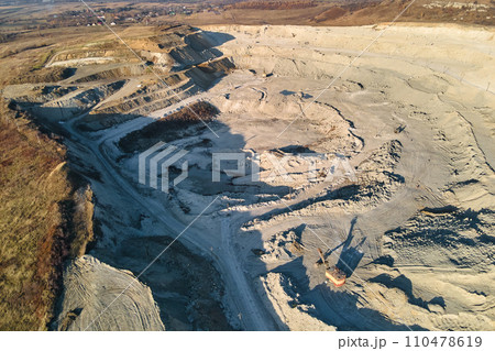 Aerial view of open pit mine of sandstone materials for construction industry with excavators and dump trucks. Heavy equipment in mining and production of useful minerals concept 110478619