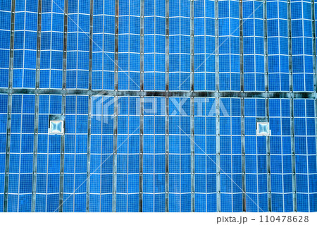 Aerial view of many photo voltaic solar panels mounted of industrial building roof. Aerial view of many photo voltaic solar panels mounted of industrial building roof. 110478628