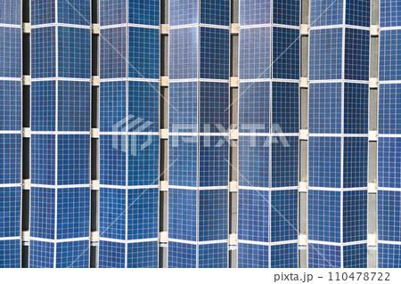 Aerial view of blue photovoltaic solar panels mounted on industrial building roof for producing green ecological electricity. Production of sustainable energy concept. Aerial view of blue photovoltaic solar panels mounted on industrial building roof for producing green ecological electricity. Production of sustainable energy concept. 110478722