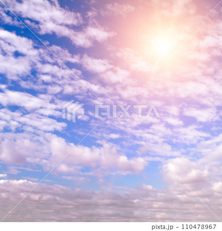 Cumulus clouds and bright sun in the sky. 110478967