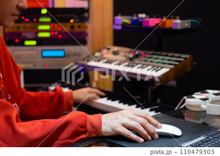 asian professional music producer, composer, arranger, songwriter arranging a hit song on computer in home recording studio. music production concept asian professional music producer, composer, arranger, songwriter arranging a hit song on computer in home recording studio. music production concept 110479303