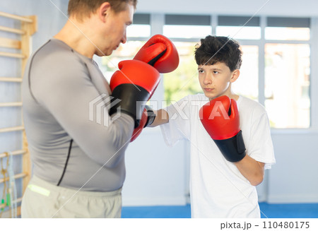 Man and boy teenager train boxing in studio 110480175