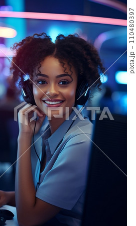 A smiling African-American woman with headphones and a microphone in a call center 110480397