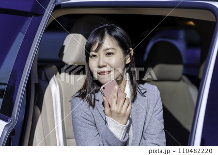 車の後部座席でスマホを使う女性 110482220