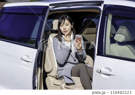 車の後部座席でスマホを使う女性 110482223