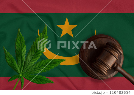 Judge wooden gavel, fresh hemp leaf against the background of Mauritania flag. Illegal sale and distribution of marijuana 110482654