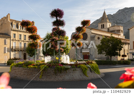 Sisteron cityscape with fountain in blooming flowers and medieval cathedral Sisteron cityscape with fountain in blooming flowers and medieval cathedral 110482929