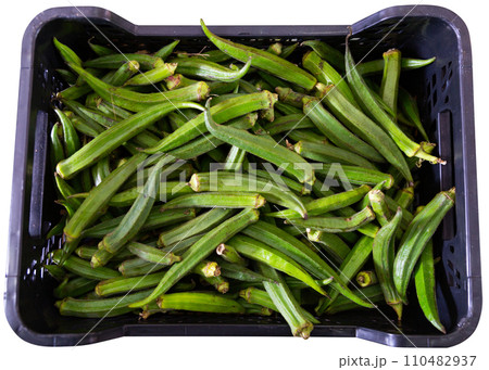 Photo shows garden stuff shop window with display plastic boxes filled with okra fruits. 110482937