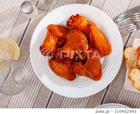 Service plate containing smoked chicken wings with necessary table laying 110482943
