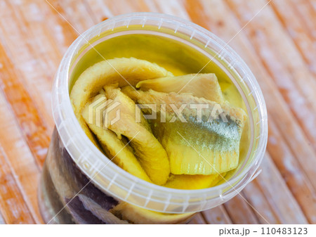 Herring served in plastic container on the table 110483123