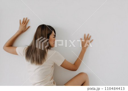 Funny woman lie on background try to spy and listen over the wall. Funny woman lie on background try to spy and listen over the wall. 110484413