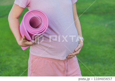 Energetic pregnant woman takes her workout outdoors, using an exercise mat for a refreshing and health-conscious outdoor exercise session Energetic pregnant woman takes her workout outdoors, using an exercise mat for a refreshing and health-conscious outdoor exercise session 110485657