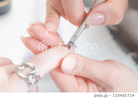 ネイルサロン_ベースジェルを塗っている 110485714