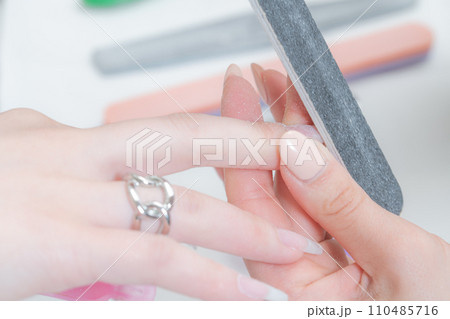 ネイルサロン_ファイルを使ってネイルの形を整えている3 110485716