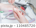 ネイルサロン_ファイルを使ってネイルの形を整えている 110485720