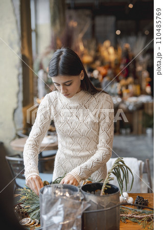 The crafted Christmas wreath is ready for sale, positioned on the flower shop counter. 110485769