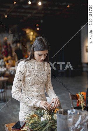 The finishing details on the Christmas wreath are completed at the flower shop counter. 110485780