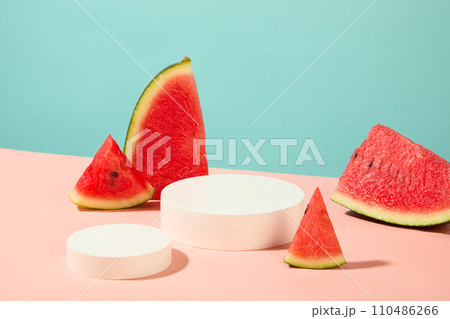 White podiums in round shaped arranged on the surface with slices of watermelon. Mock-up for exhibitions or presentation of cosmetic products or packaging White podiums in round shaped arranged on the surface with slices of watermelon. Mock-up for exhibitions or presentation of cosmetic products or packaging 110486266