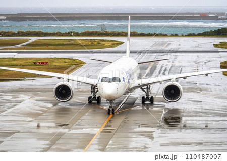 雨の空港　タキシング中の飛行機　沖縄県那覇市 110487007