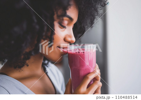 Close-Up of Woman with Berry Smoothie in Modern Scandi Apartment 110488514