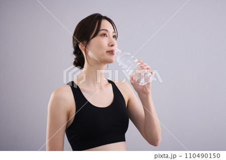 スポーツウェアで水分補給する女性 スポーツウェアで水分補給する女性 110490150