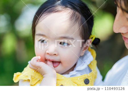 お父さんに抱かれて指しゃぶりをする幼い女の子 お父さんに抱かれて指しゃぶりをする幼い女の子 110493126