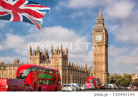 Big Ben with red buses on the bridge against flag of England in London, England, UK 110493143