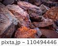 Big seaside rock texture concept photo. Panoramic Mediterranean close up red stones. 110494446