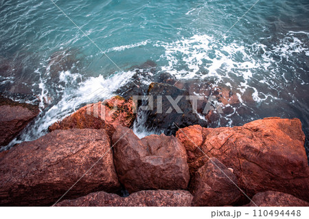 Mediterranean winter stormy seaside. Close up water with stones on the beach concept photo. 110494448